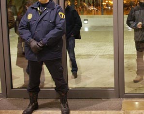 Un policia identifica les persones que accedeixen a l'edifici.